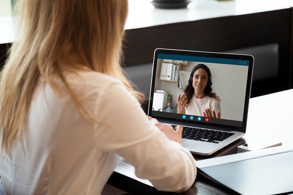 Young woman holding video call conversation with female colleague